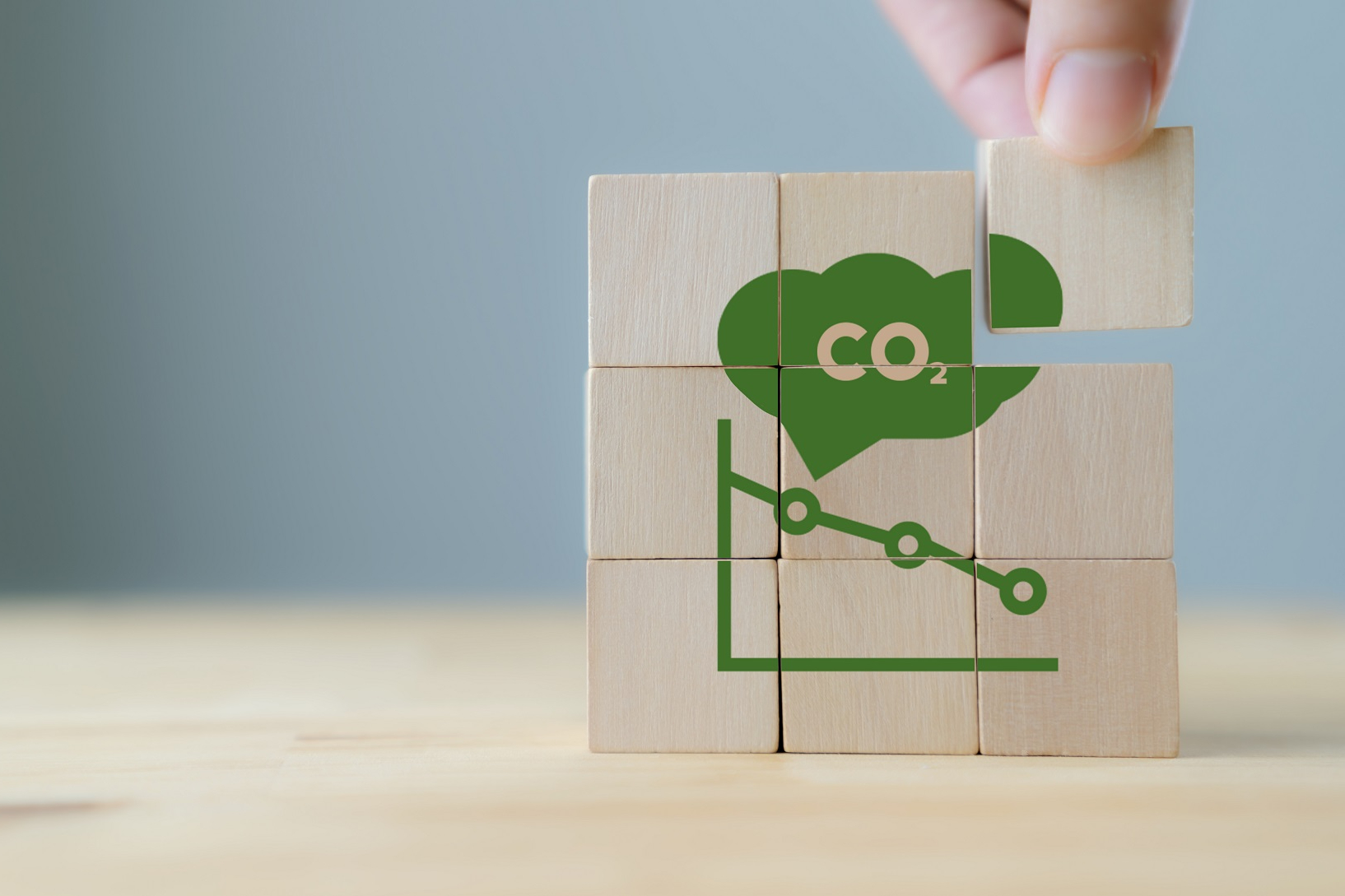 CO2 emission concept. Green industries business concept. Net zero emissions. Renewable energy, sustainable technology, ecology solutions. Hand puts the wooden cubes with CO2 emission reduction icon.