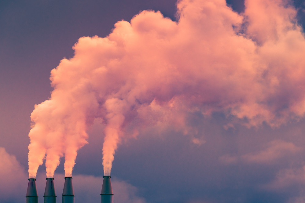 Smoke and steam rising into the air from power plant stacks