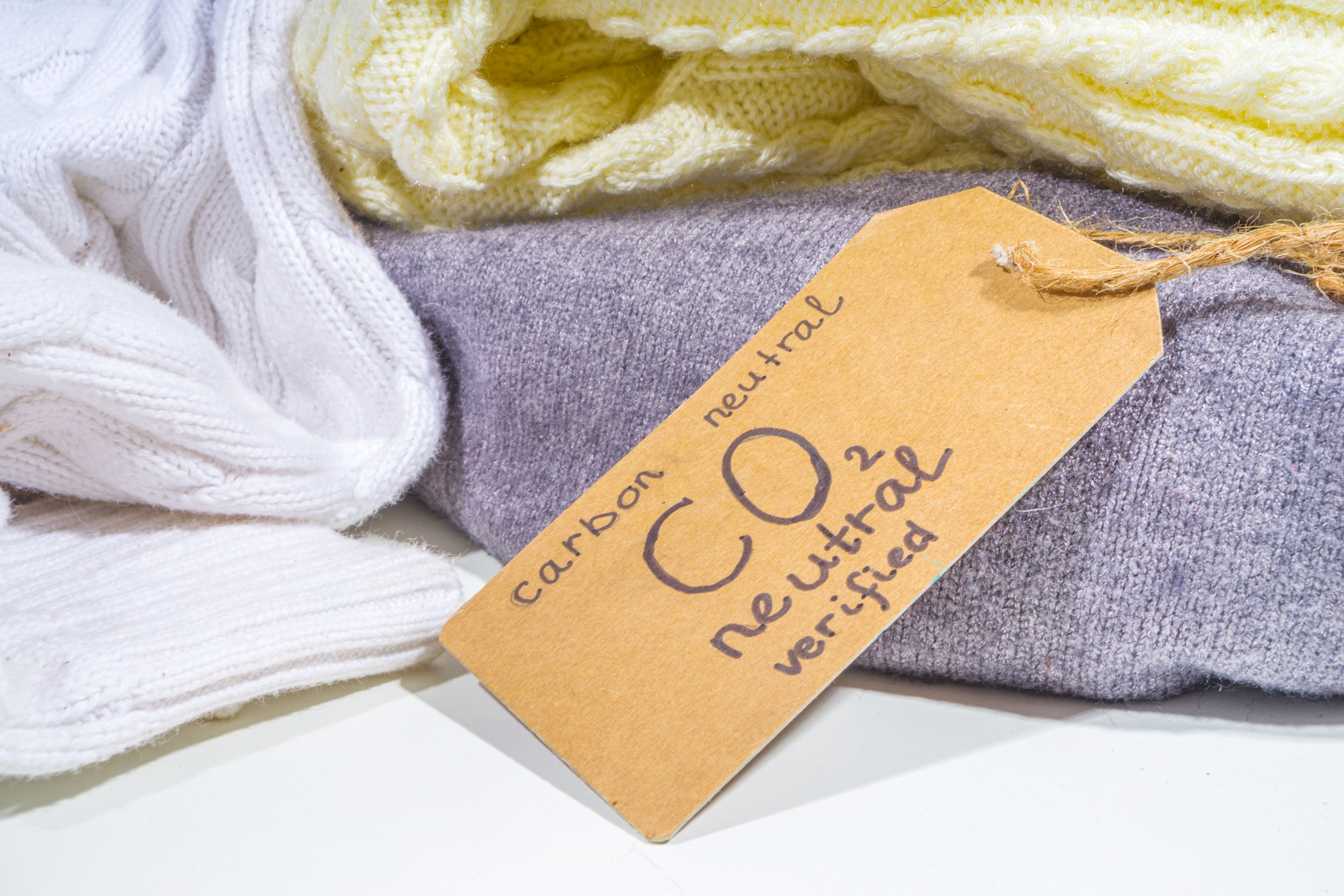 Carbon neutral, CO2-free concept product. Natural organic cotton clothing, with CO2 neutral tag verified, on a desk.